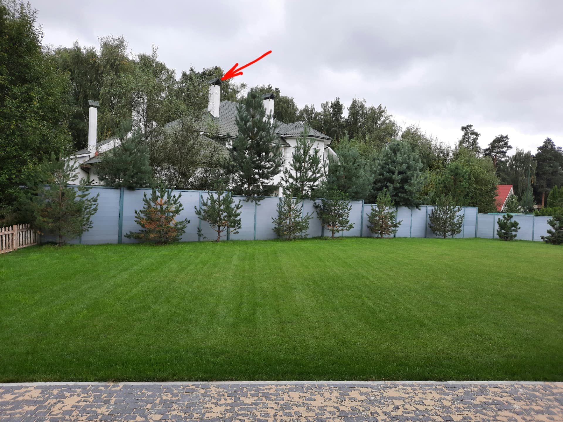 A house across the garden with the distant chimney marked