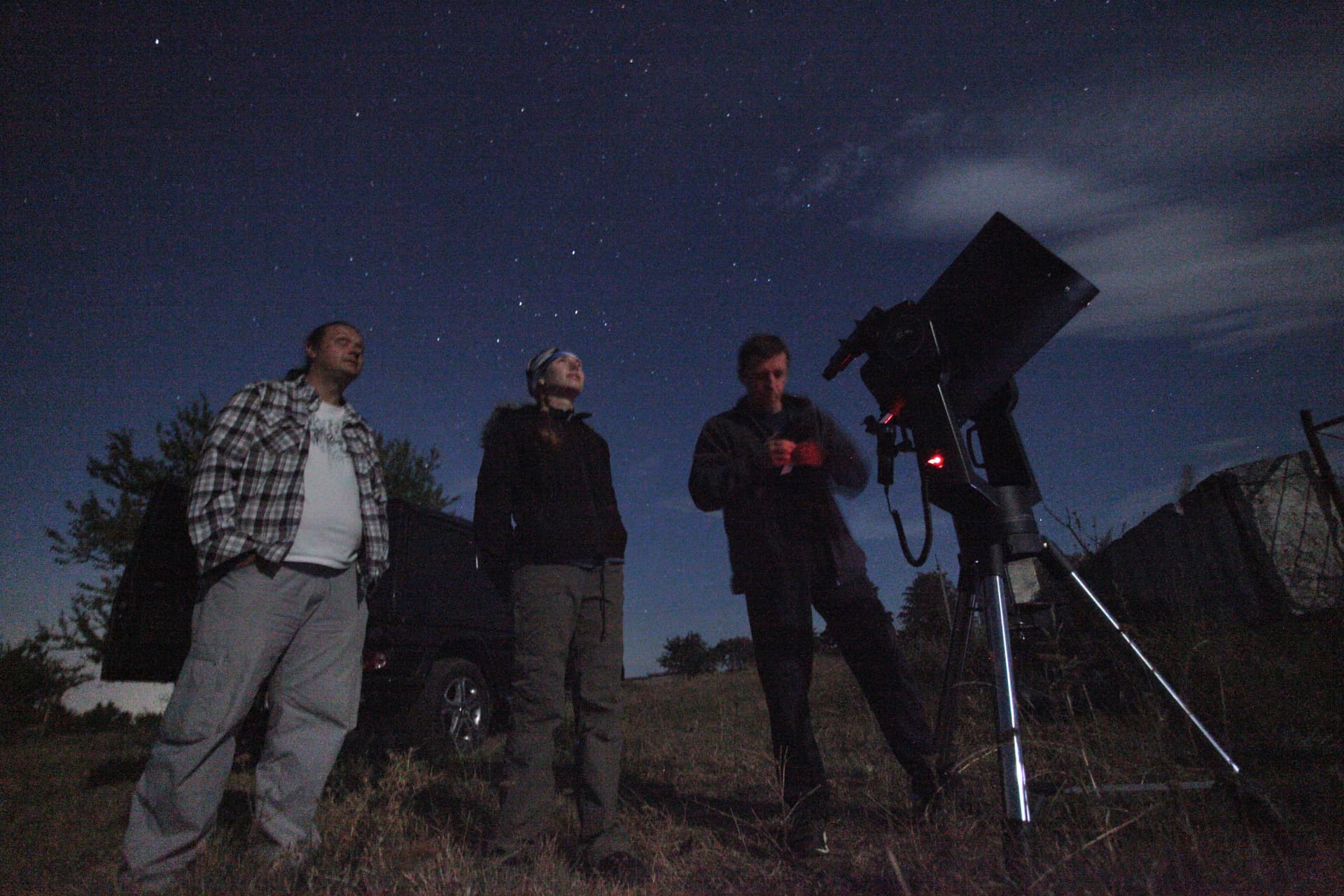 Guests looking up at the night sky beside the telescope