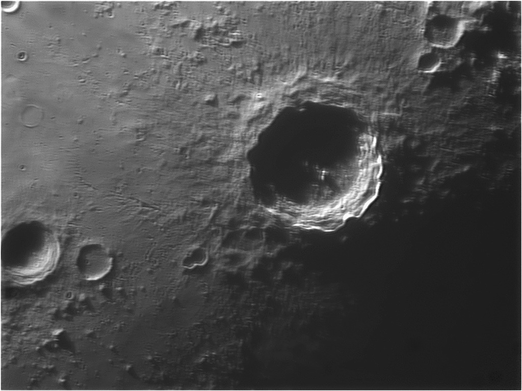 A single lunar crater with terraced walls in shadow